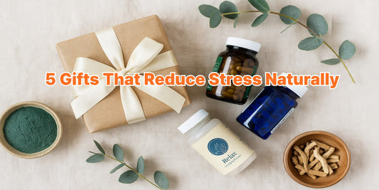A wrapped gift box surrounded by supplement bottles, spirulina powder, eucalyptus leaves, and dried herbs on a soft fabric background.